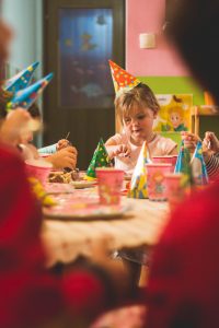 Anniversaire d'une petite fille, à table avec ses invités devant son gâteau