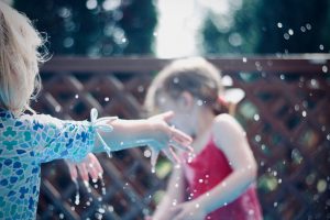 Petites filles jouant avec de l'eau dans un jardin